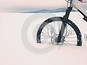 The front wheel of mountain bike stay in powder snow. Lost path