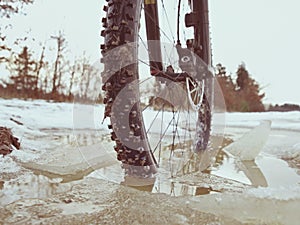 Front wheel of mtb blocked in ivy pool, extreme cycling in winter landscape. Broken ice floe