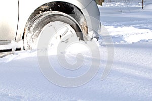 Front wheel of vehicle driving on snow winter road