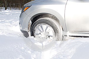 Front wheel of vehicle driving on snow winter road