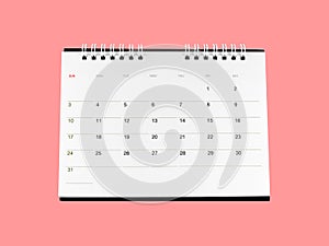 front of white cardboard desk calendar with days and dates isolated on pink background