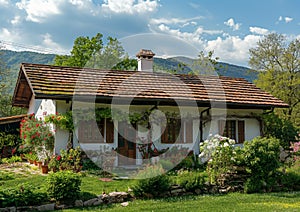 the front of a white house with brown roof and red shutters