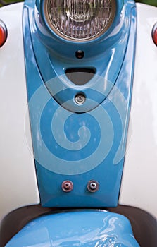 Front wing and headlight of blue retro scooter