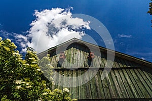 Front of wooden barn with dark blue sky with clouds.