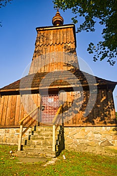 Front of the Wooden church of Saint Michael the Archangel in Prikra during summer sunset