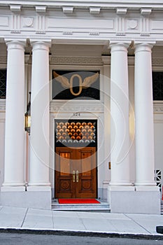 Front wooden door of classical building with four pillars