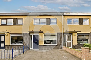 the front of a yellow house with a blue door