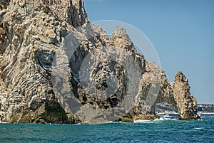Frontal south view on El Arco behind tall boulder, Cabo San Lucas, Mexico photo