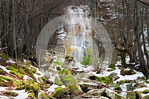 Frontal view of iconic waterfall Tupavica during winter and rocky creek
