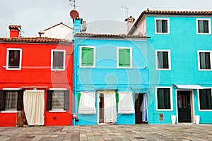 Fronts of the bright red, blue and turquoise houses on the island of Burano, Venice, Italy