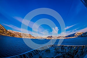 Frontside view from hurtigruten Ship cruise, with a gorgeous coast with buildings in the horizont