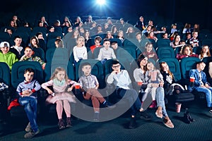 Frontview of people sitting in the cinema hall.