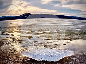 Frost crystal border between floe and dark water on lake. Natural view