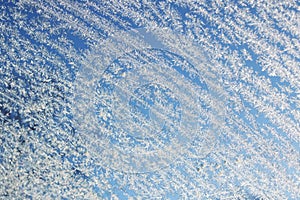 Frost pattern on glass on blue sky background