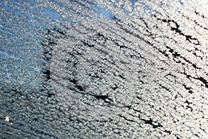 Frost pattern on glass on blue sky background