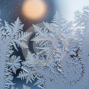 Delicate frost patterns form intricate, fern-like shapes on a glass surface. The frost's icy
