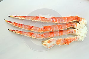 frosted Alaska king crab legs closeup photo on white table background