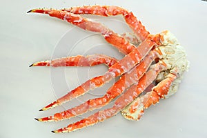 frosted Alaska king crab legs closeup photo on white table background