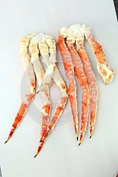 frosted Alaska king crab legs closeup photo on white table background