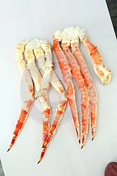 frosted Alaska king crab legs closeup photo on white table background