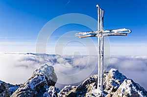 Frosted cross on a mountain peak Velky Rozsutec in Mala Fatra in Slovakia