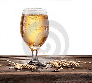 Frosted glass of beer on the wooden table.