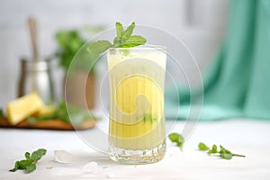 frosted glass of pineapple juice with a sprig of mint on top