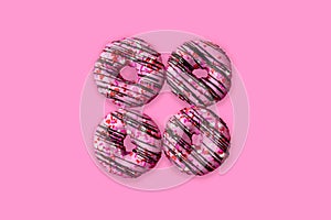 Frosted pink donuts with heart shaped sprinkles
