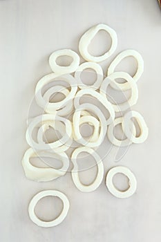 frosted squid body rings clos up photo on white table background