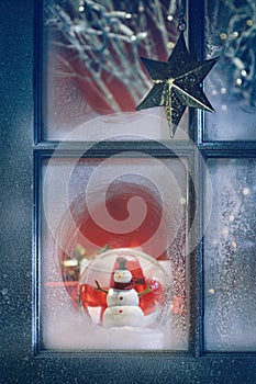 Frosted window with Christmas decorations inside