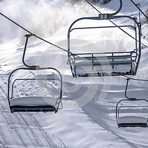 Frosty chair lifts against sunlit snow in winter