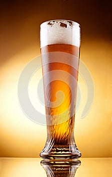 Frosty glass of light beer with froth