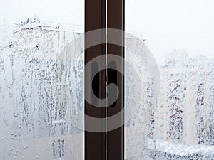 Frosty home window in house in city in winter