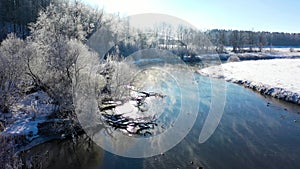 Frosty morning on the river in a light fog. A frost in the trees by the river. Beautiful rural winter landscape