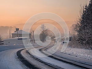 Frosty morning sunrise winter snow-covered highway through Cherdyn village