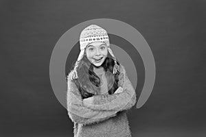 Frosty weather. Winter outfit. Cute model enjoy winter style. Small child long hair wear hat red background. Wintertime