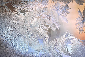 Frosty Window Glass with Natural Ice Patterns and Blurred Colorful Background. Winter Holidays Season, Fantasy World Concept