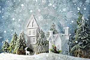 Frosty winter wonderland forest with snowfall, houses and trees. Christmas greetings concept