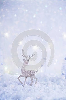 Frosty winter wonderland with toy deer, snowfall and magic lights.