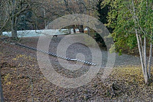 Frosty wooden stairs on the river bank and colored maple leaves. Yellow autumn, natural environment background.