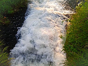 the froth of rushing water in the village river