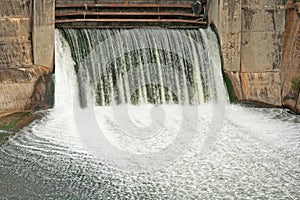 FROTHING WATER SPILLING OUT OF A SLUICE GATE