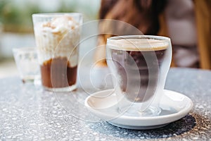 Frothy Nitro Cold Brew Coffee in drinking glass on granite top table with blur background