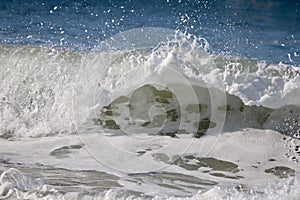 Frothy wave on blue ocean