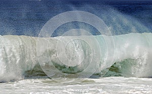 Frothy wave crashes on shore at Aliso Beach in Laguna Beach, California. photo