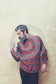 Frown bearded man with beard holding metal mug