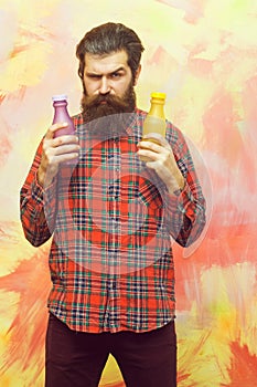 Frown bearded man holding two plastic bottles