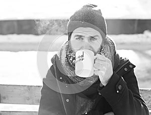 Frown man, bearded hipster with beard and moustache covered with white frost drinks from cup with good morning text