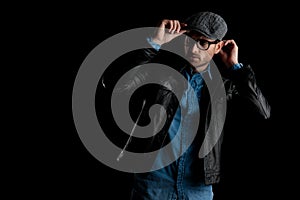 Frown man with eyeglasses adjusting his cap with both hands