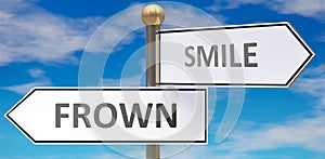 Frown and smile as different choices in life - pictured as words Frown, smile on road signs pointing at opposite ways to show that